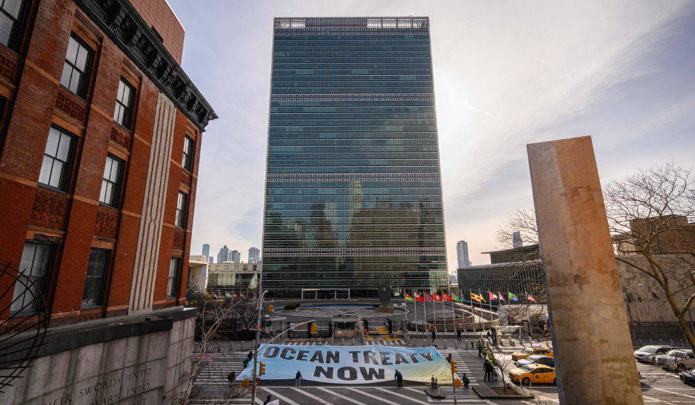 Activists from Greenpeace display a banner before the United Nations headquarters during ongoing negotiations at the UN on a treaty to protect the high seas in New York on February 27, 2023. (AFP)