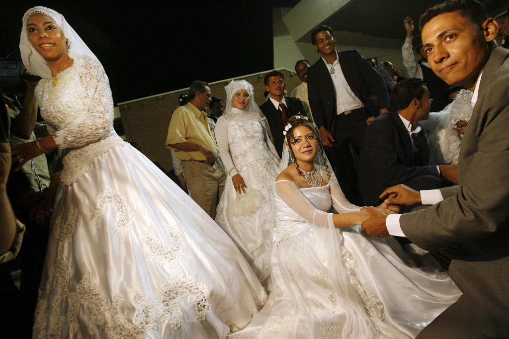 Above, Egyptian couples dance during their collective wedding at a hall in Cairo. (AFP file photo)