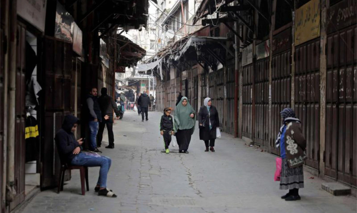 People walk past closed shops in Lebanon’s northern port city of Tripoli. (AFP/File)