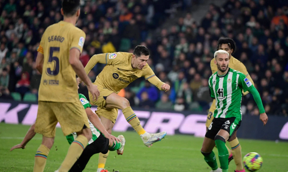 Barcelona’s Polish forward Robert Lewandowski (C) kicks the ball and scores a goal during their Spanish league football match against Real Betis at the Benito Villamarin stadium in Seville on Wednesday. (AFP)