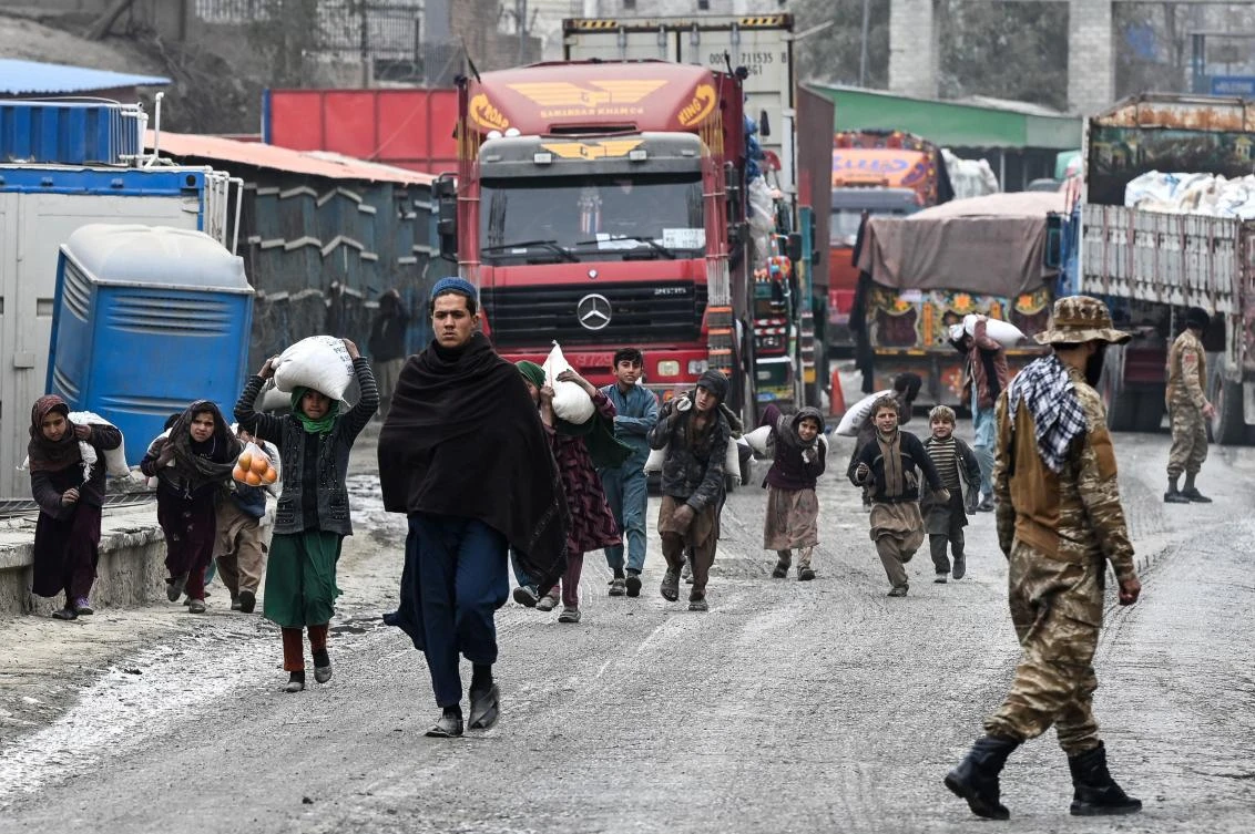 Afghan child workers carry sacks of sugar at the zero point Torkham border crossing between Afghanistan and Pakistan. (AFP)