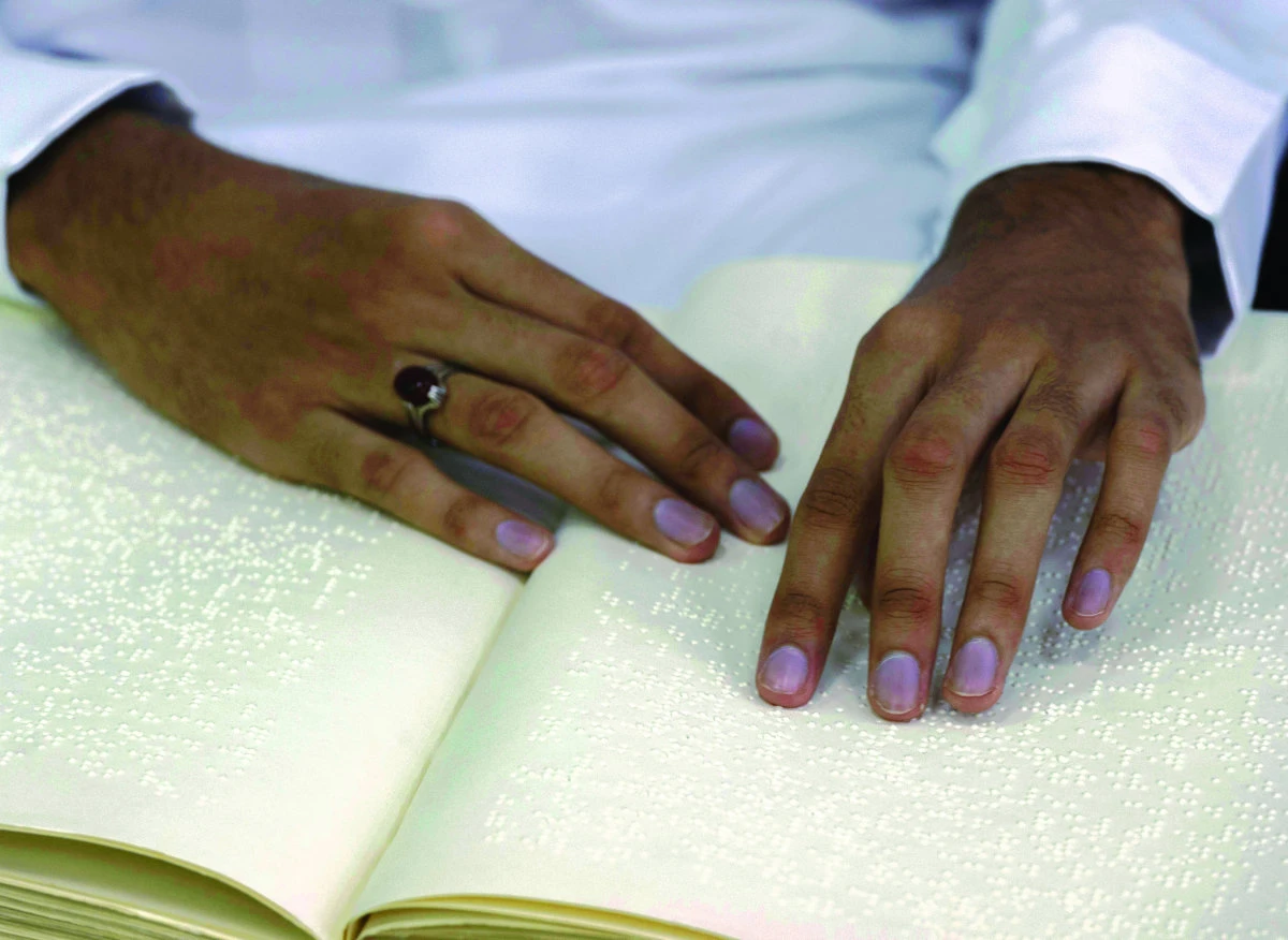 A blind Saudi man recites from a braille copy of the Qu’ran in a mosque on the first day of Ramadan in Qatif, Saudi Arabia. (Right)
