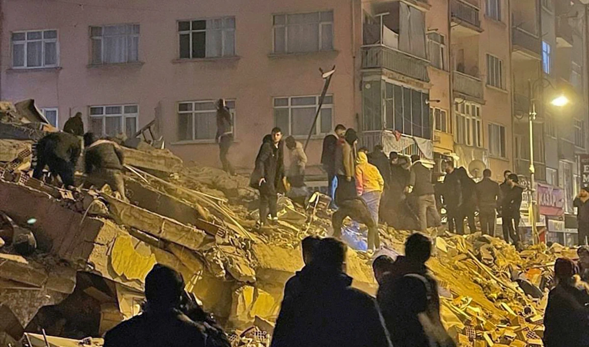 People try to reach trapped residents in a collapsed building in Diyarbakir, southeastern Turkey, on February 6, 2023. (Depo Photos via AP)