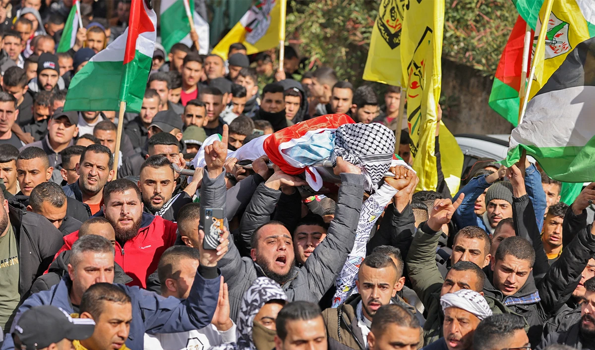 Palestinians carry the body of Abdullah Sami Qalalweh during his funeral at his village of al-Judaydeh south of Jenin in the occupied West Bank, on February 4, 2023. (AFP)