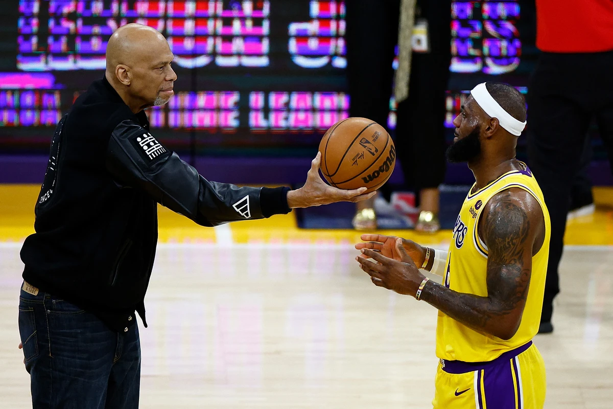 Kareem Abdul-Jabbar hands LeBron James of the Los Angeles Lakers the ball after James passed Abdul-Jabbar to become the NBA's all-time leading scorer. (AFP)