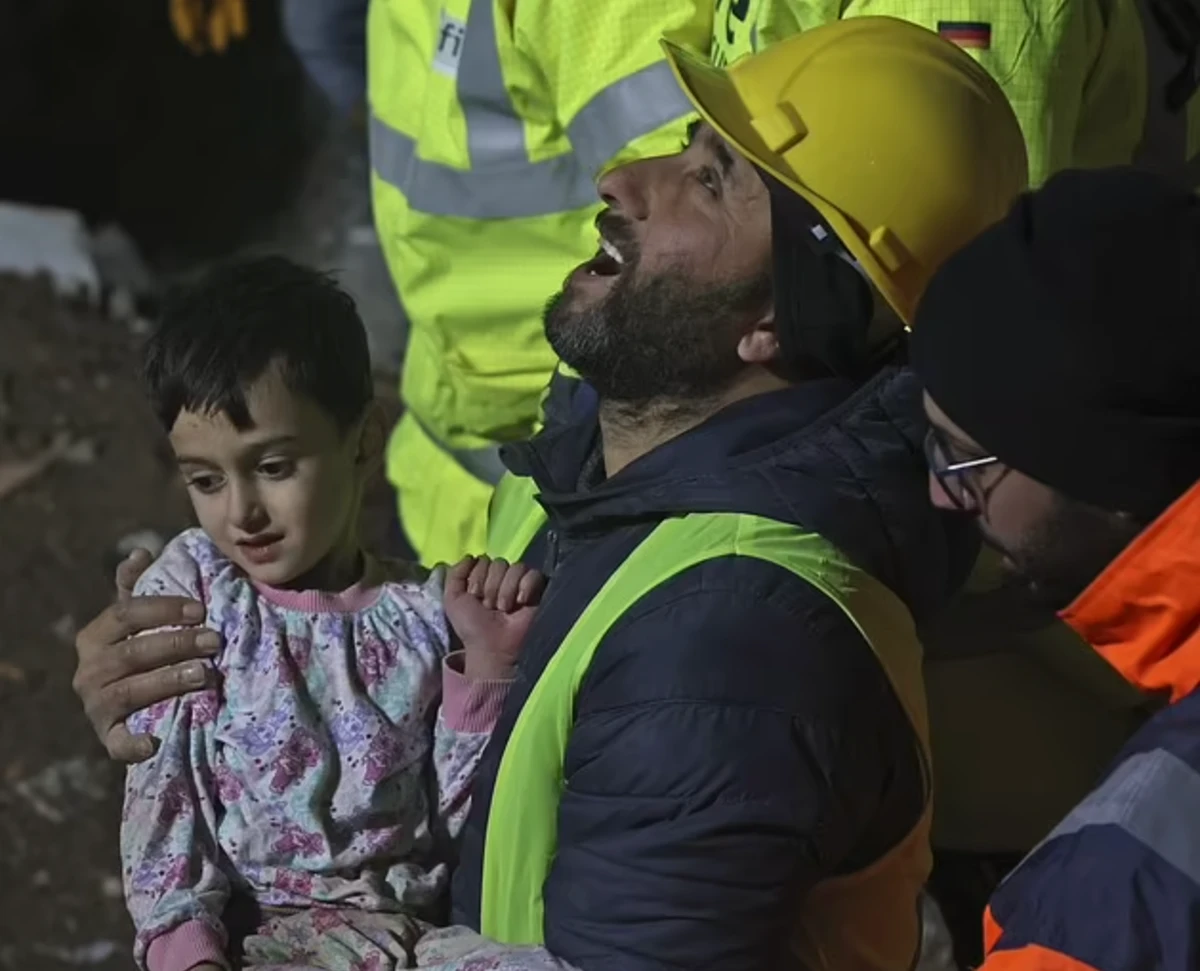 A volunteer carries 5-year-old Mehmet Topal after being rescued from a collapsed building in Kahramanmaras. (Getty Images)