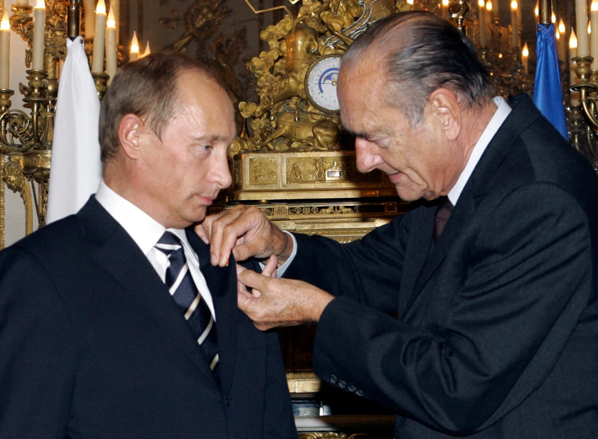 In this photo taken on Sept. 22, 2006, French President Jacques Chirac, right, hands over a rosette of the Legion of Honor to visiting Russian President Vladimir Putin at the Elysee Palace in Paris. (ITAR-TASS via AP, File)