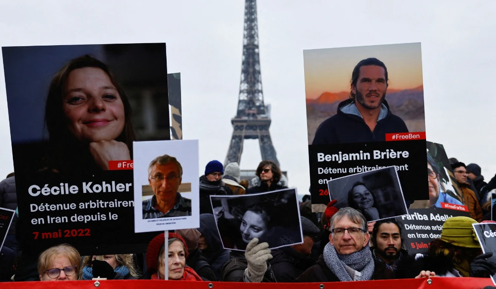 Supporters and relatives of French citizens detained in Iran gather in front of the Eiffel Tower in Paris during a rally demanding their release. (Reuters)