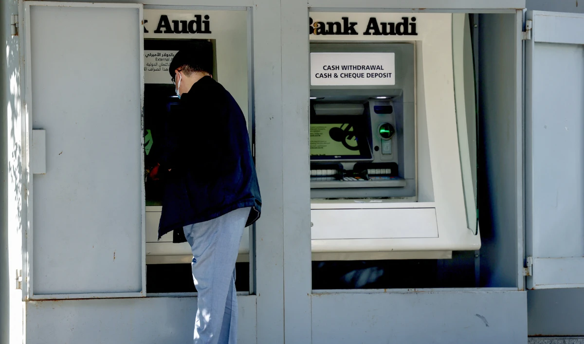 A man withdraws cash from an ATM machine outside a bank in Lebanon's capital Beirut, on January 20, 2023. (AFP/File)
