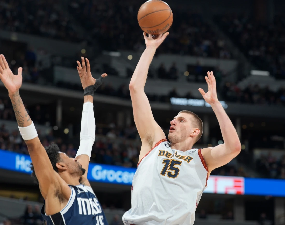Denver Nuggets center Nikola Jokic, right, goes up for a basket over Dallas Mavericks forward Christian Wood in the second half of an NBA basketball game Wednesday in Denver. (AP)
