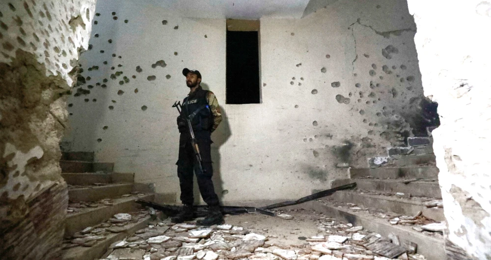 A police officer stands guard after an attack on a police station in Karachi. (Reuters)