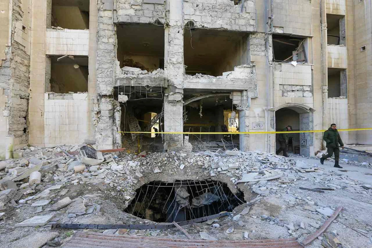 Syrian security forces members inspect a building damaged in a reported Israeli missile strike in Damascus on February 19, 2023. (AFP)