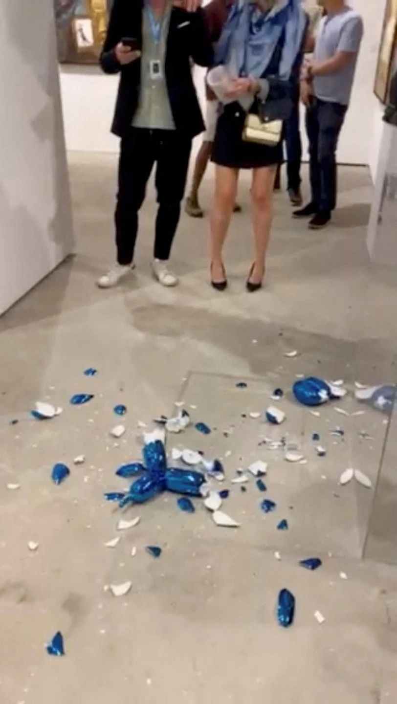 Pieces of a damaged Jeff Koons sculpture lie on the floor at Art Wynwood in Miami, Florida, U.S. February 16, 2023 in this still image obtained from social media video. (REUTERS)