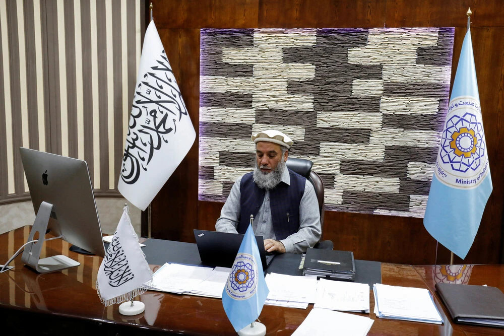 Nooruddin Azizi, acting Afghan Minster of Commerce and Industry, works on his laptop at his office in Kabul, Afghanistan, February 22, 2023. (Reuters)
