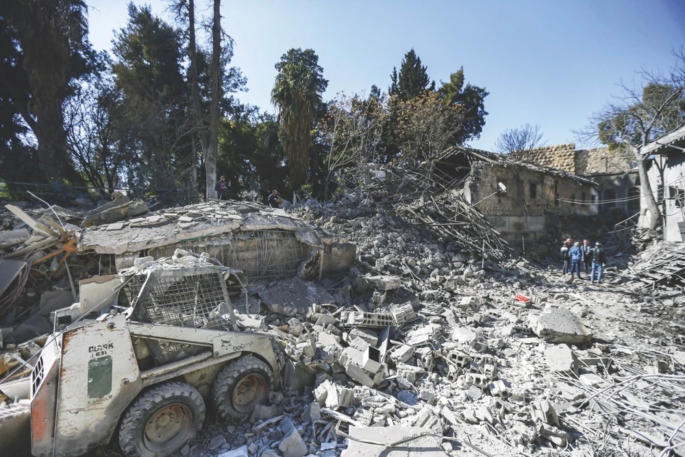 People inspect the damage in the aftermath of an Israeli airstrike, allegedly targeting a logistics center run by the IRGC, which killed five people and damaged several buildings in Syria’s capital Damascus on Sunday, Feb. 19. (AFP)