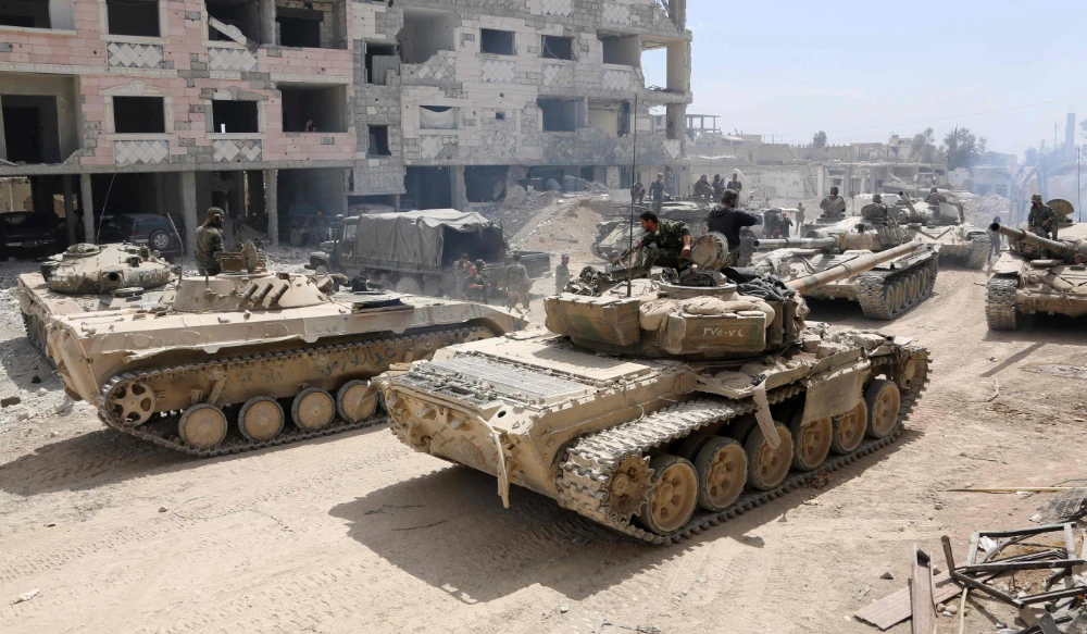 A picture taken on April 8, 2018, shows Syrian Army soldiers gathering in an area on the eastern outskirts of Douma, as they continue their fierce offensive to retake the last opposition holdout in Eastern Ghouta. (AFP)