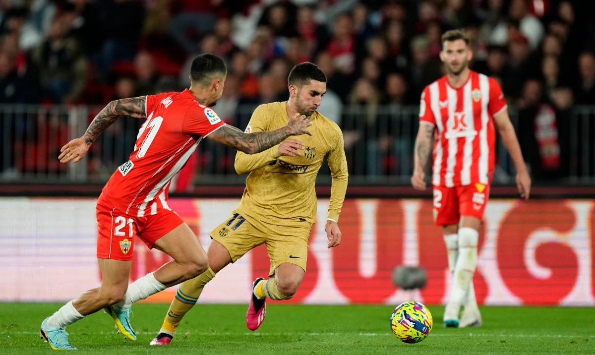 Barcelona's Ferran Torres, right, vies for the ball with Almeria's Chumi during the Spanish La Liga soccer match between Almeria and Barcelona at the Juegos Mediterraneos stadium in Almeria, Spain on Feb. 26, 2023. (AP)