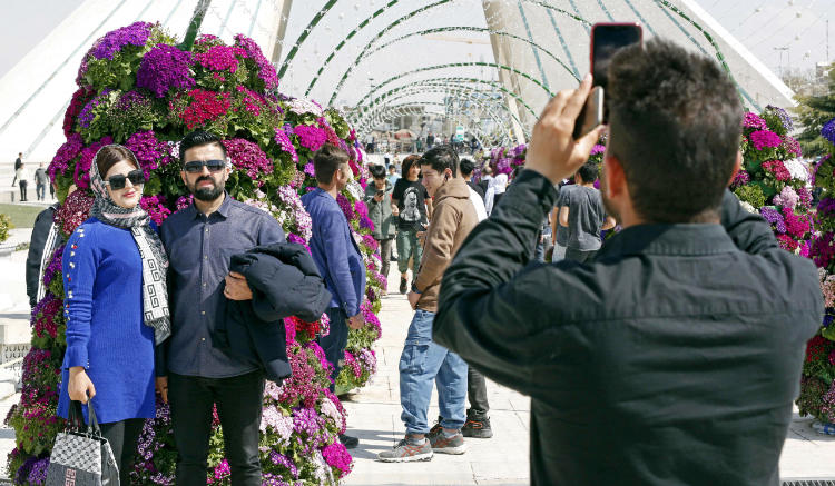 People gather around colourful eggs in Tehran on March 20, 2023 as they celebrate the Persian New Year Nowruz. (AFP)