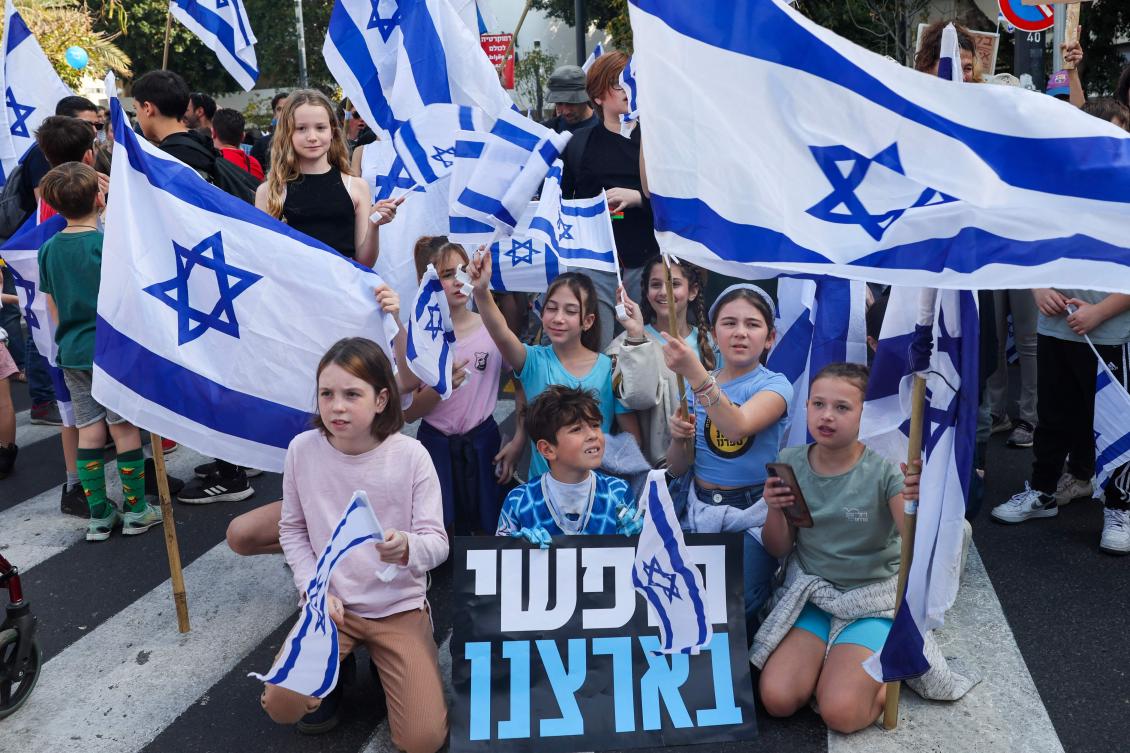 Protesters blocked the main highway from Tel Aviv to Jerusalem on Wednesday, waving blue and white Israeli flags. (AFP)