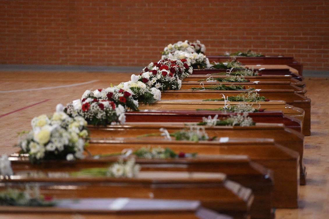 A photograph taken on February 28, 2023 shows the coffins of the migrants who died two days day before, after their boat sank off Italy's southern Calabria region, at the Crotone Palasport, the funeral home for the victims, in Steccato di Cutro, south of Crotone. (AFP)