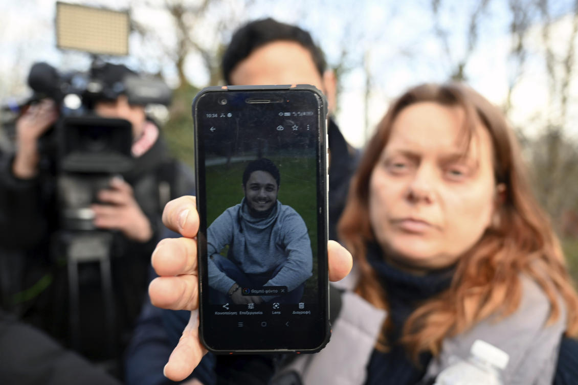 Mirela Ruci shows to the media a photo of his 22-year old missing son Denis Ruci, outside a hospital in Larissa city, about 355 kilometers (222 miles) north of Athens, Greece, Friday, Mar. 3, 2023. (AP)