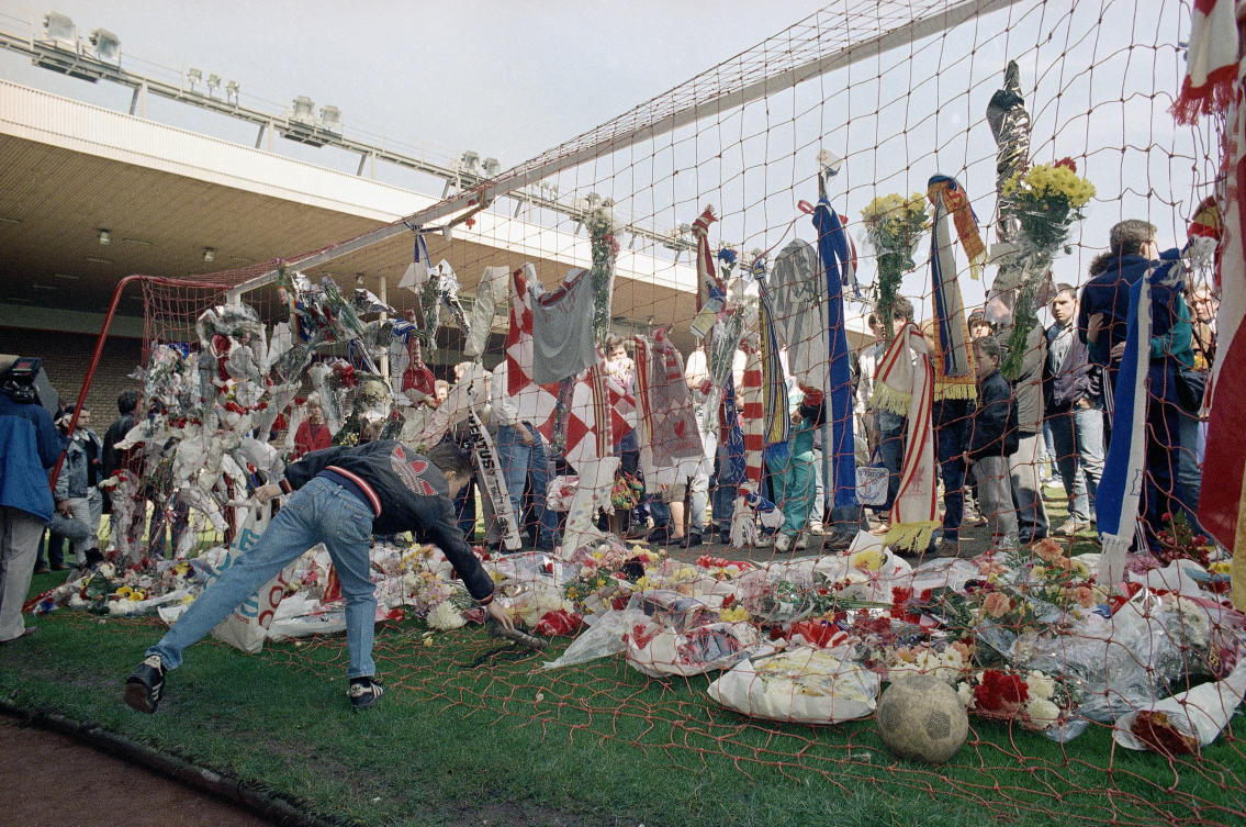 In this file photo dated April 16, 1989, a Liverpool Football Club fan places a pair of football boots in the goal at the Kop end of Anfield Stadium as hundreds came to mourn the loss of fellow Liverpool fans. (AP/File)