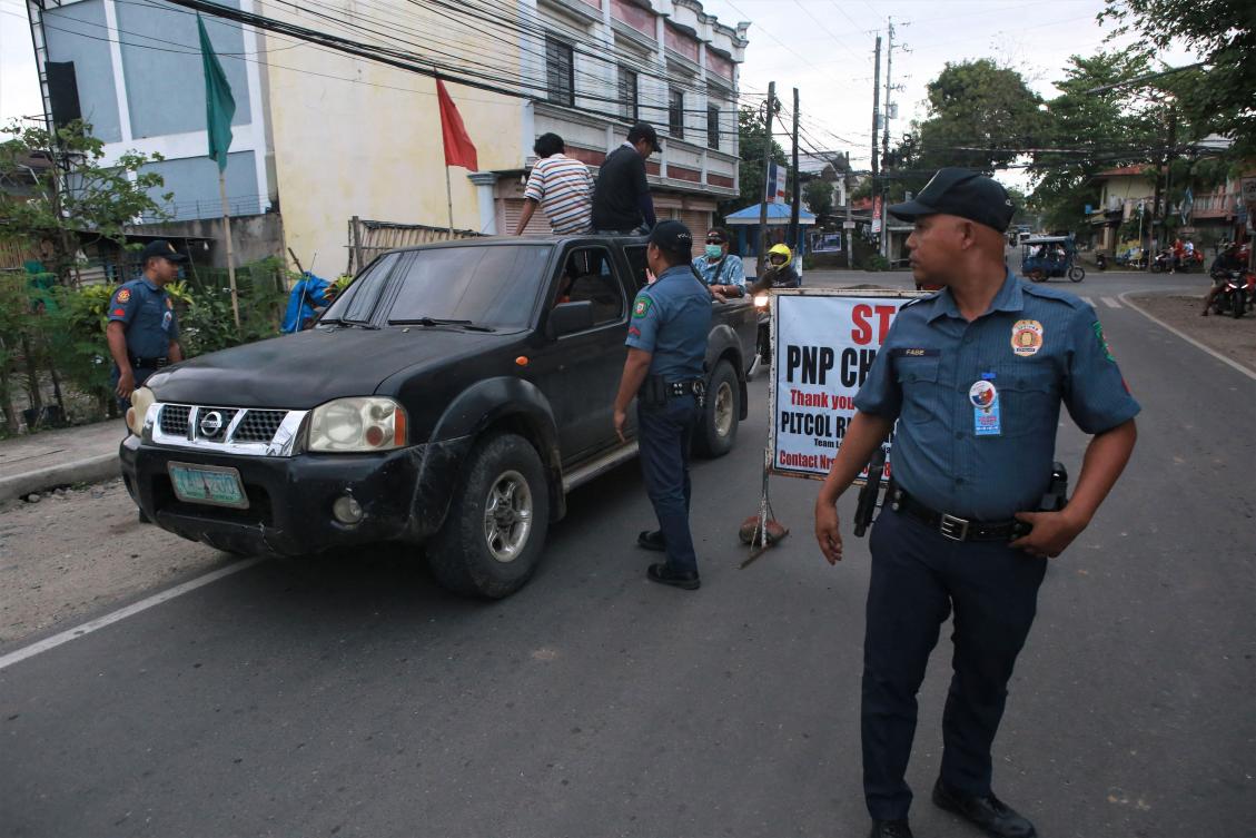 Policemen man a checkpoint between the border of Tanjay City and Pamplona town in the Philippine Province of Negros Oriental on March 4, 2023, hours after the provincial governor Roel Degamo and five others were killed by unknown gunmen. (AFP)