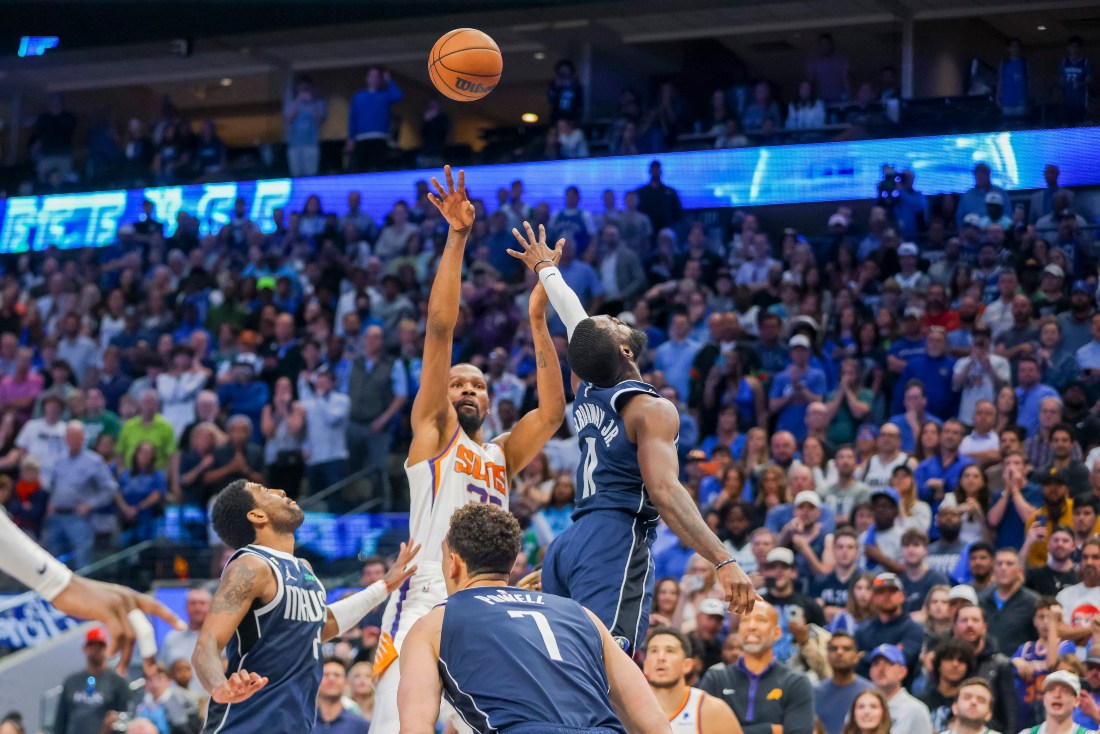Phoenix Suns forward Kevin Durant, center back, shoots the game-winning basket over Dallas Mavericks forward Tim Hardaway Jr., right, and guard Kyrie Irving, left, during second half of an NBA game, Sunday in Dallas. (AP)