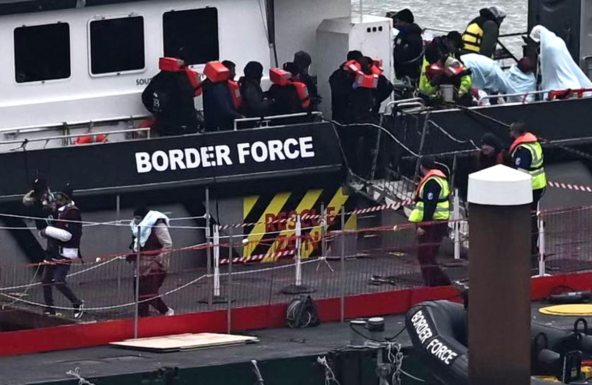 Migrants are escorted ashore from the UK Border Force vessel ‘BF Ranger’ in Dover, southeast England, on March 6, 2023, after having been picked up at sea while attempting to cross the English Channel. (AFP)