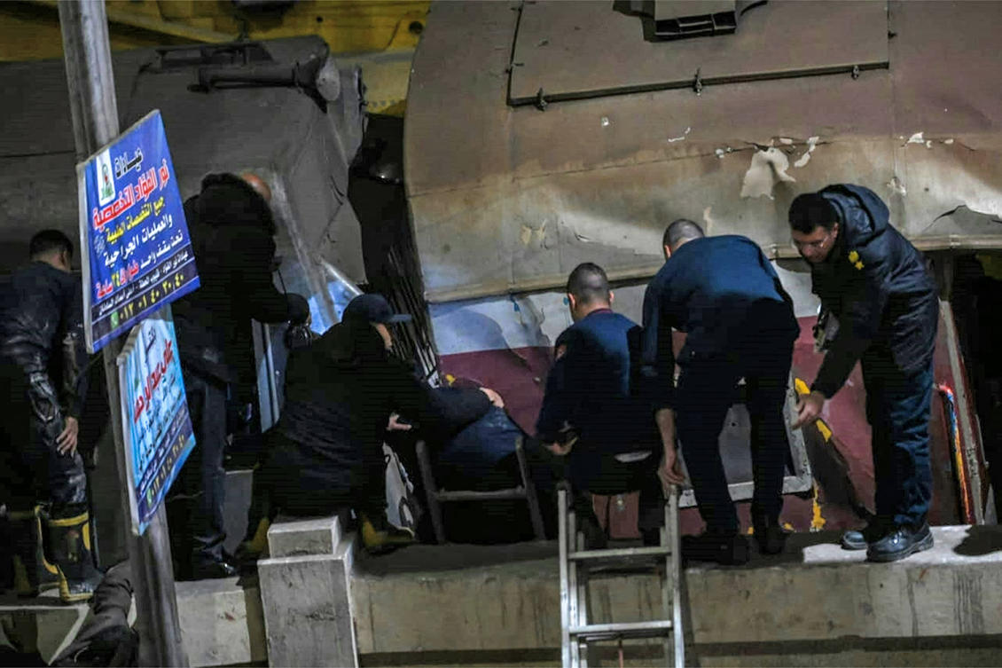 Policemen and first responders arrive at the scene of a train accident in the city of Qalyub in Qalyub province. (AFP)