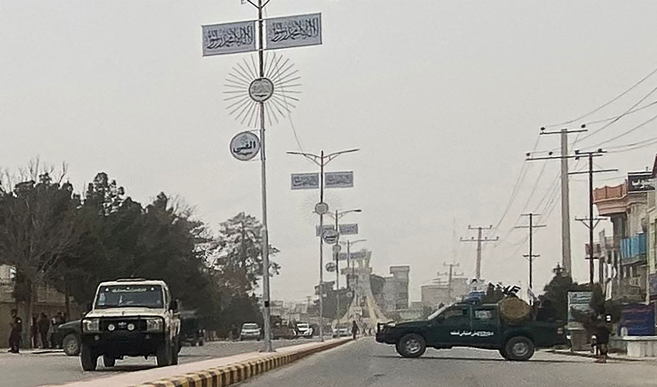 Taliban security personnel (R) block a road in Mazar-i-Sharif on March 9, 2023, following a blast at the office of Taliban governor of Afghanistan's Balkh province. (AFP)