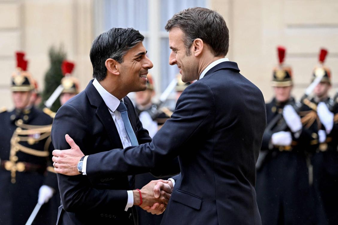 France's President Emmanuel Macron (R) shakes hands with Britain's Prime Minister Rishi Sunak as he arrives for a meeting on the occasion of the 36th Franco-British bilateral summit at the Elysee Palace. (AFP)