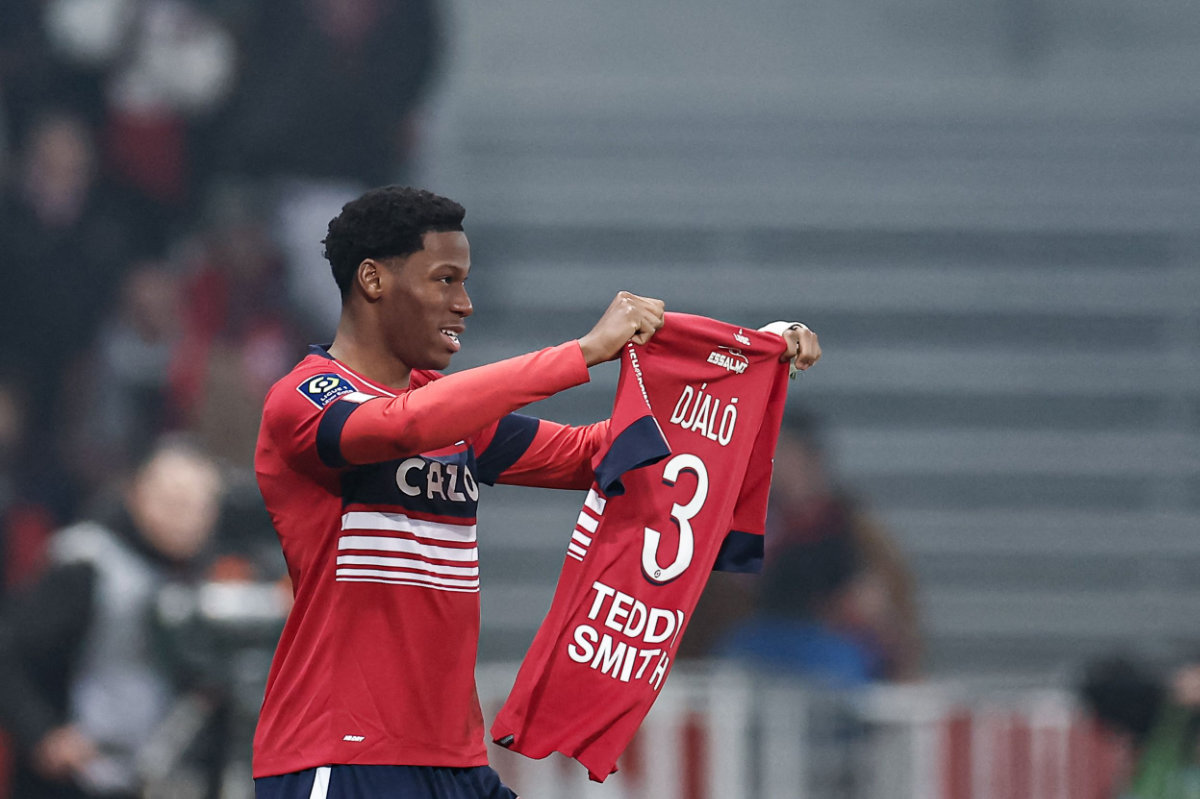 Lille's Canadian forward Jonathan David raises the jersey of his injured teammate Portuguese defender Tiago Djalo as he celebrates scoring their first goal during the French L1 match against Olympique Lyonnais (OL) at Stade Pierre-Mauroy on Thursday. (AFP)