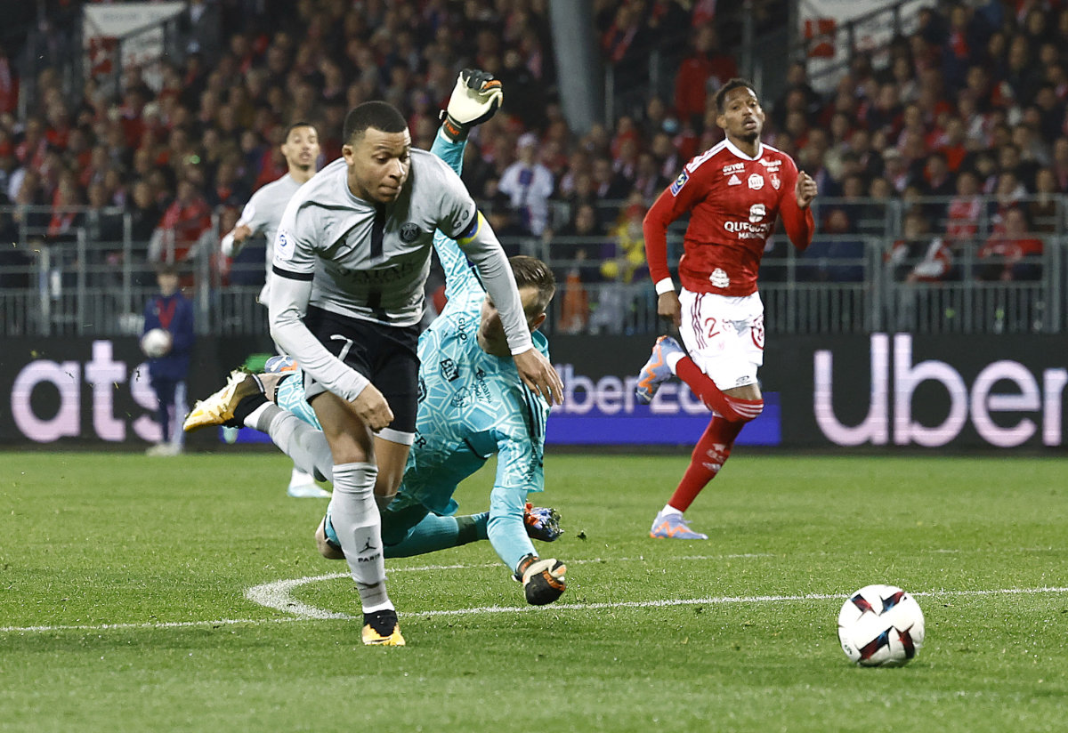 Paris St Germain's Kylian Mbappe goes past Brest goalkeeper Marco Bizot before scoring their second goal during their French league match on March 11, 2023. (Reuters)
