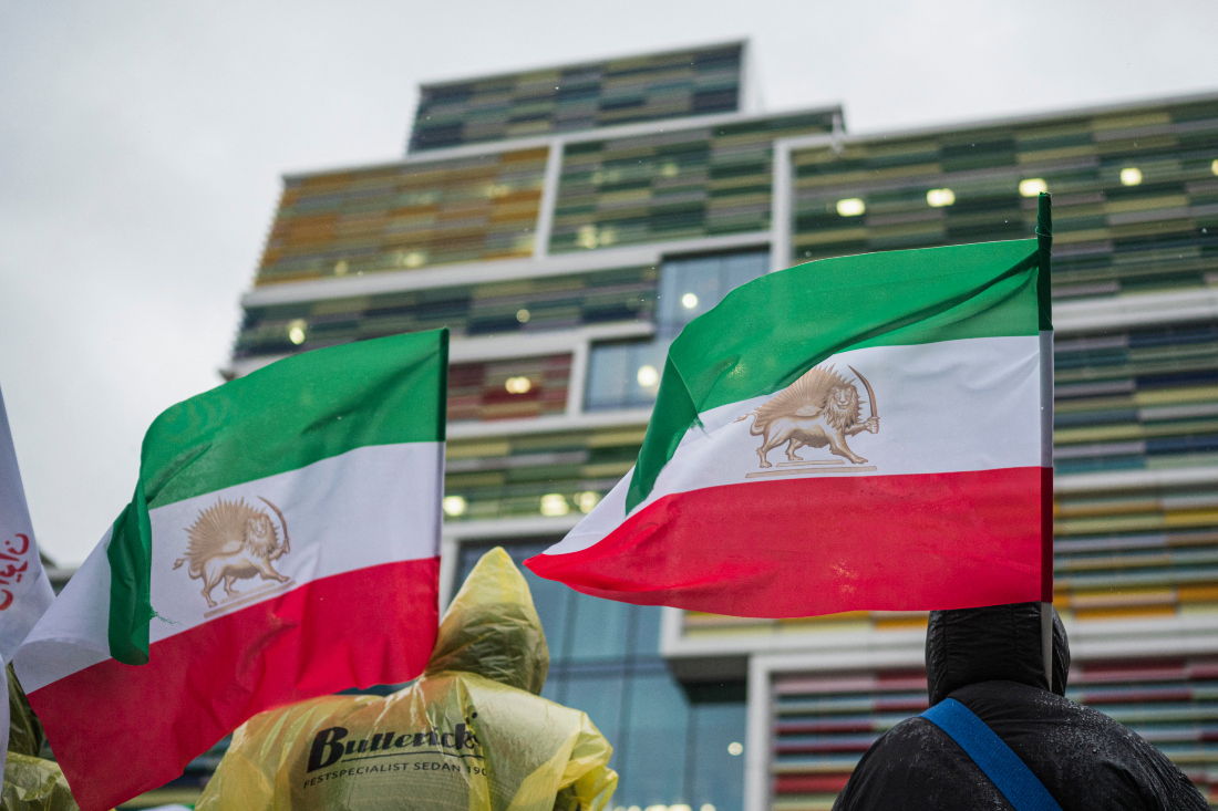 Protesters wave a historic Iranian flag with the Lion and Sun symbol as they gather outside of the Appeals Court building in Sollentuna, north of Stockholm, Sweden. (File/AFP)