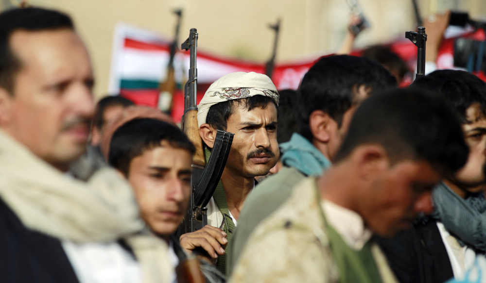 A supporter of the Shiite Houthi movement chews qat as he holds up his weapons during a march in the capital Sanaa. (AFP)
