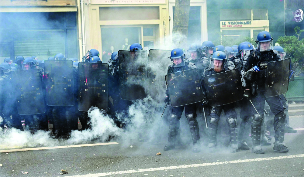 French gendarmes face protesters during a demonstration, as part of a nationwide day of strikes and protests called by unions on Saturday. (AFP)