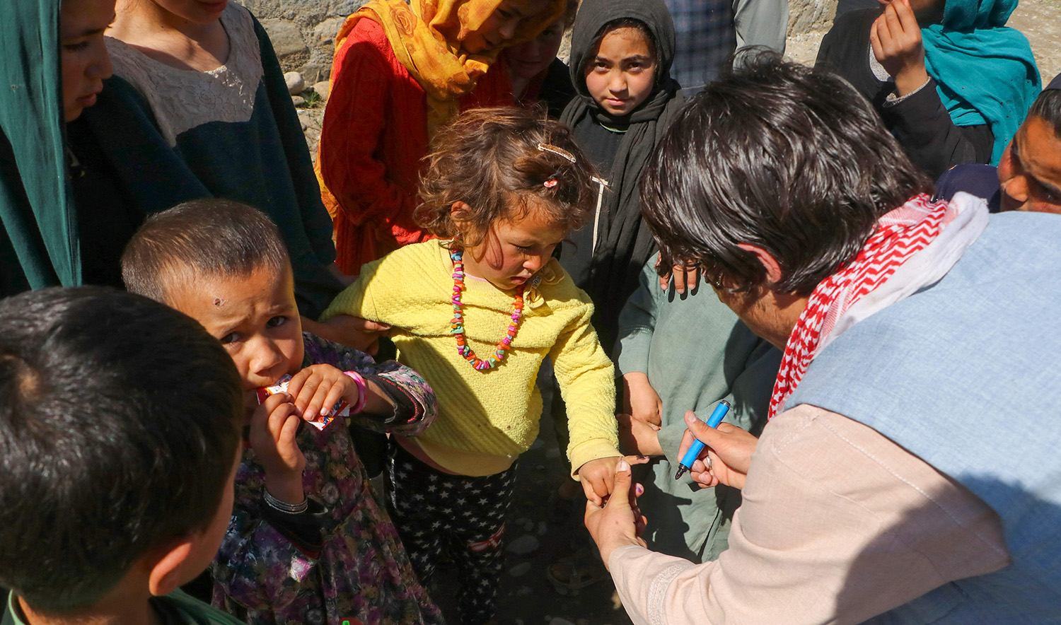 An Afghan health worker marks a child's finger after administering polio drops during a vaccination campaign in Fayzabad district of Badakhshan province on March 13, 2023. (AFP)