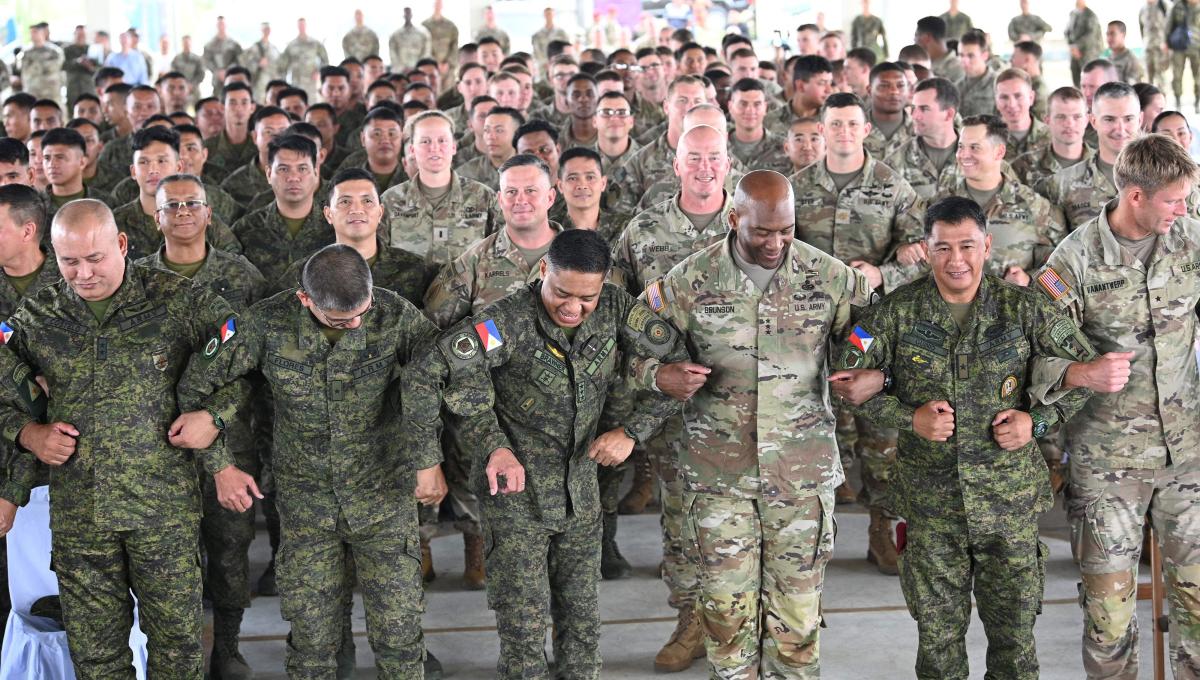 Philippine and US army officials link arms during the opening ceremony for this year’s ‘Balikatan’ or ‘shoulder-to-shoulder’ drills at Fort Magsaysay in Nueva Ecija on March 13, 2023. (AFP)