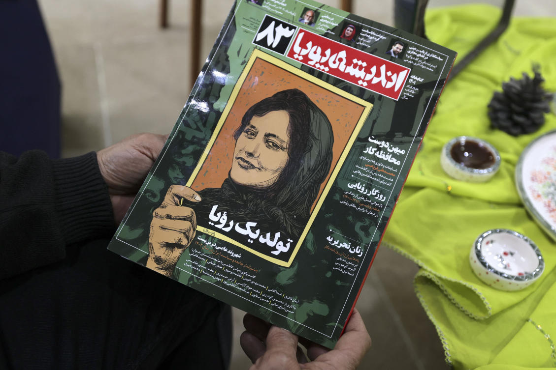 A person holds a copy of Iranian Magazine Andisheh reporting on the death of Mahsa Amini. (AFP)