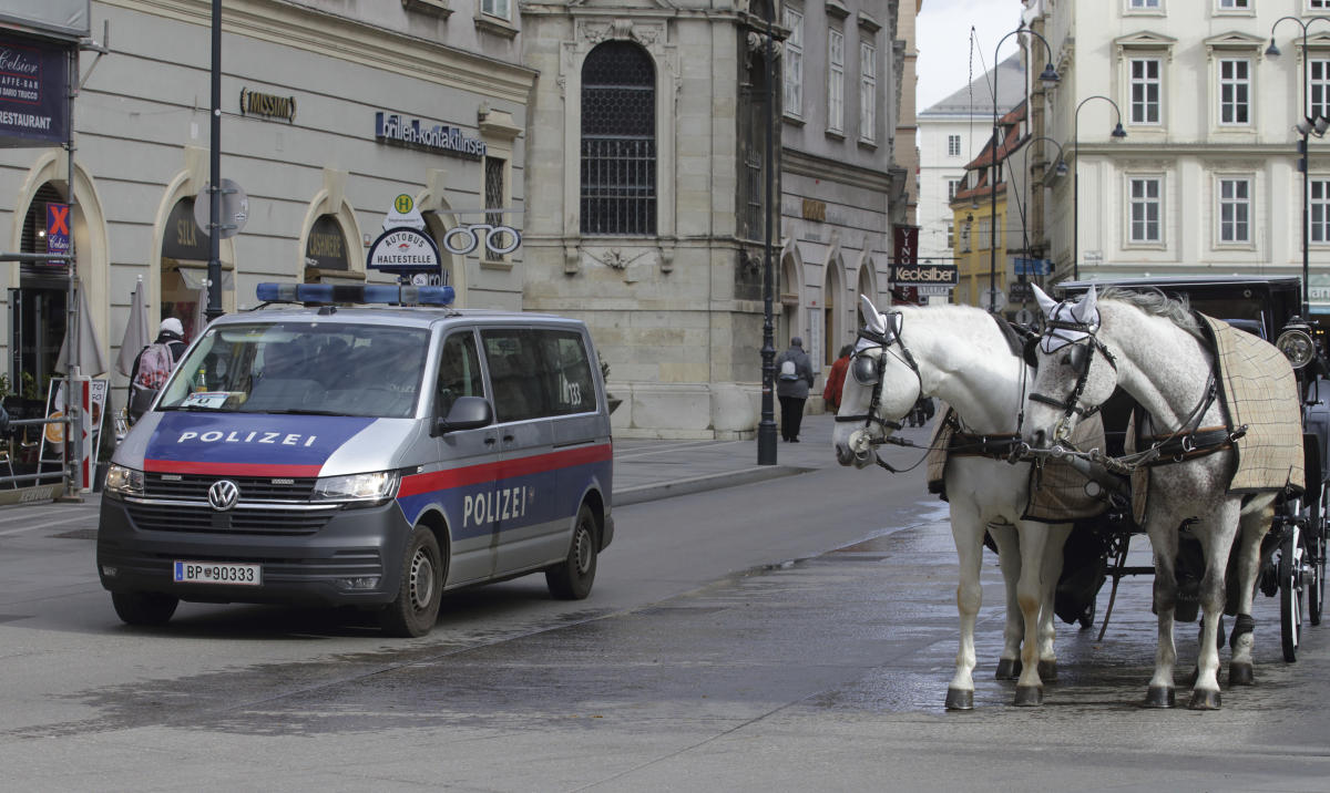 A police van drives past Fiaker horses at St. Stephen’s cathedral in Vienna on Mar. 15, 2023. (AP)