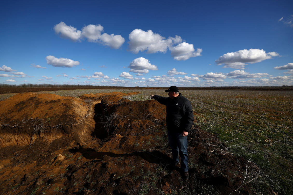 Grain farmer Oleksandr Klepach points at trenches in his field, amid Russia's invasion of Ukraine, in Snihurivka, southeast Ukraine. (File/Reuters)