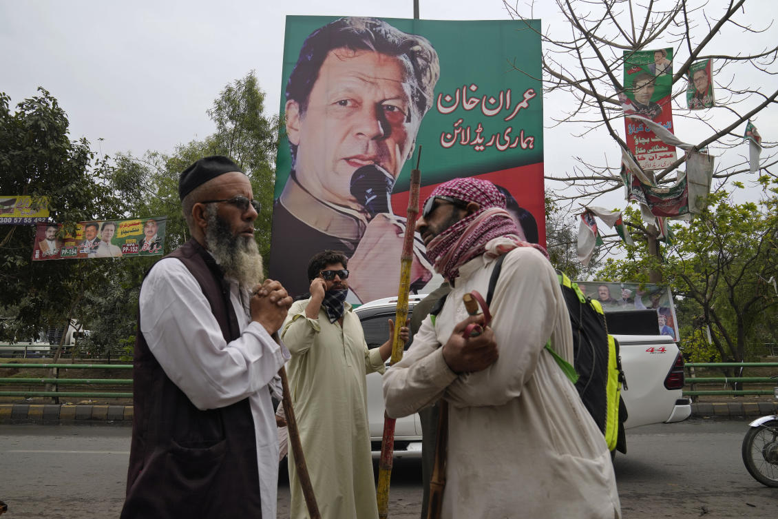Supporters of former Prime Minister Imran Khan gather with sticks near the Khan's residence, in Lahore, Pakistan, Friday March 17, 2023. A Pakistani court rejected a petition from Khan's lawyers to suspend a warrant for him to appear in court in a graft case linked to his term in office, a development that increases the likelihood of another police attempt to arrest the ousted premier. Khan has been holed up in his home in the eastern city of Lahore, where clashes erupted earlier this week when police tried to detain him. (AP Photo/K.M. Chaudhry)