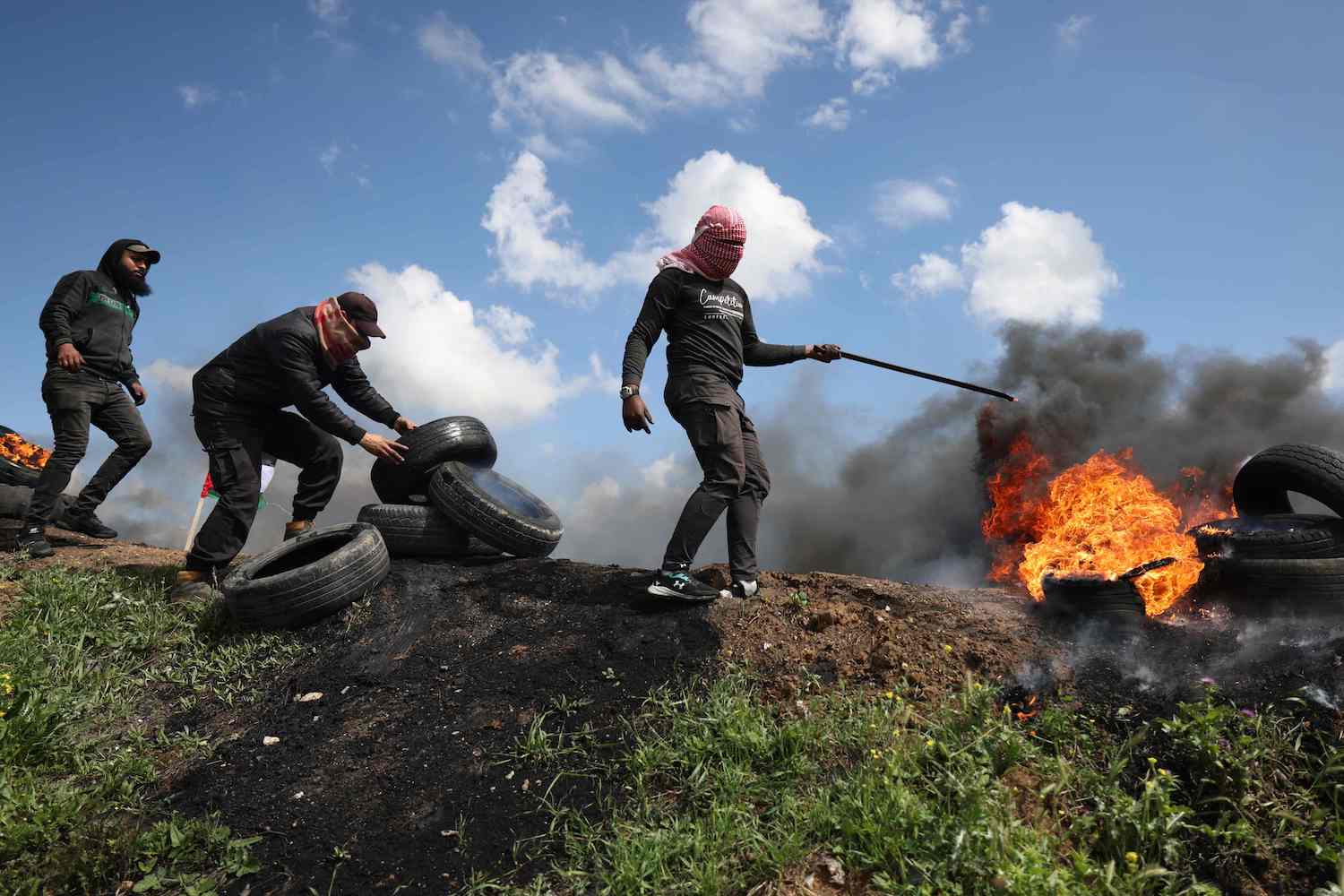 Palestinian protesters burn tyres during a small protest called for by Hamas east of Gaza City by the border with Israel on March 19, 2021. (AFP)
