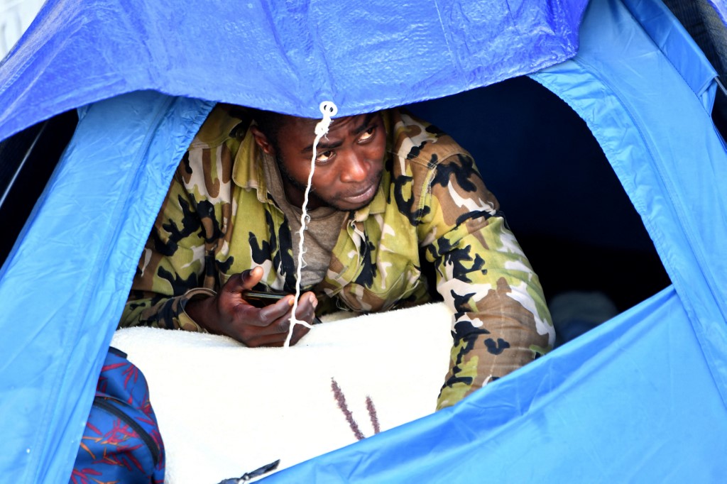 Above, a migrant camps outside the headquarters of the International Organization for Migration in Tunis, on March 7, 2023. (AFP)