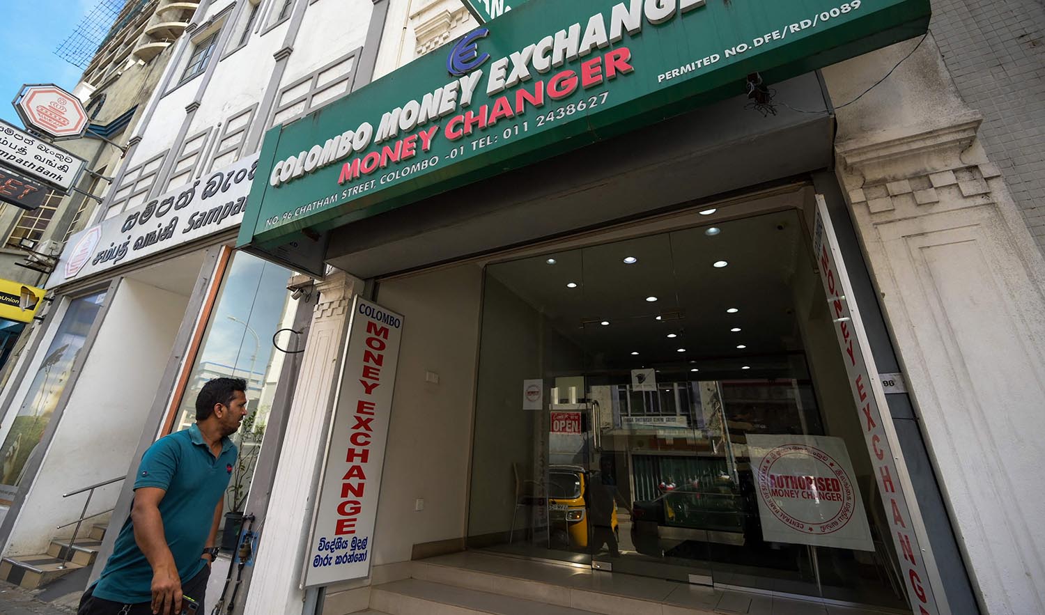 A Sri Lankan man walks past currency exchange shop in Colombo on March 20, 2023. (AFP)