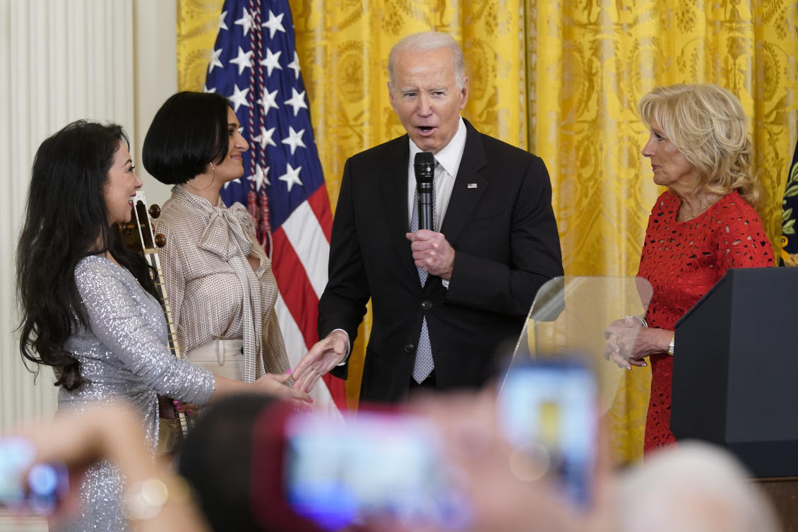 Joe Biden, accompanied by first lady Jill Biden, shakes hands with performer Sahba Motallebi, left, as he speaks during a Nowruz celebration, White House, March 20, 2023, in Washington. (AP Photo)