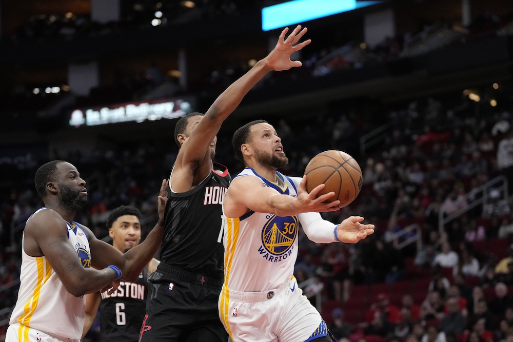 Golden State Warriors' Stephen Curry (30) shoots as Houston Rockets' Jabari Smith Jr. (1) defends during the second half of an NBA game Monday in Houston. The Warriors won 121-108. (AP)