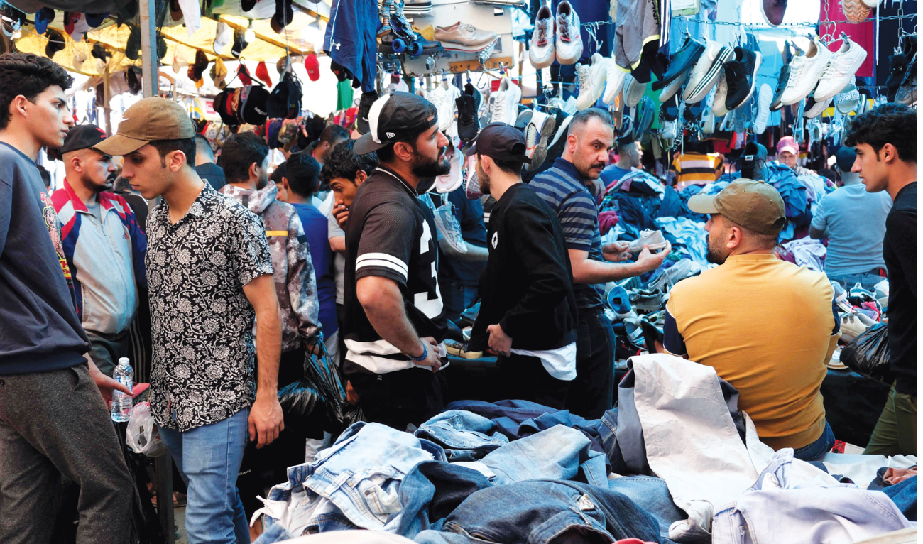 People shop at a flea market in Baghdad. Many young people in climate-stressed Iraq have become passionate about vintage clothing. (AFP)