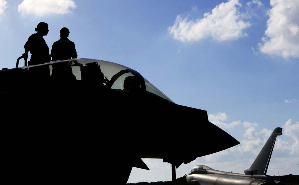 This photo taken on September 22, 2016 shows British soldiers standing on a Britain's Royal Air Force Eurofighter Typhoon fighter jet before taking off from RAF's Akrotiri base in Cyprus, for a coalition mission over Iraq. (AFP)